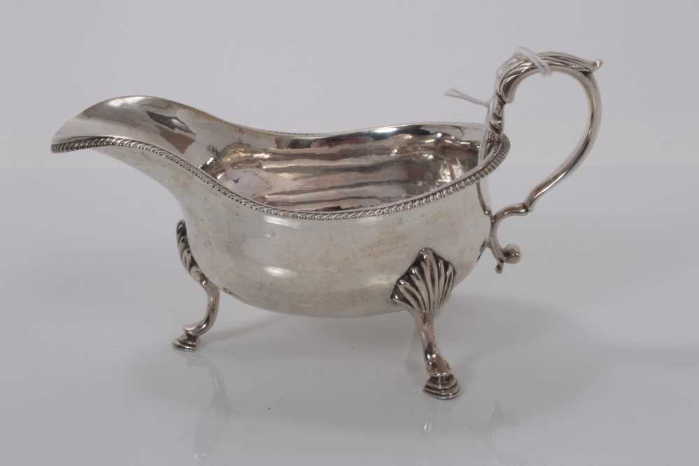 Lot 3 - George V silver sauce boat of helmet form with gadrooned border raised on three hoof feet, (London 1917), maker Pairpoint Bros, 16.6cm long, (6.8oz)