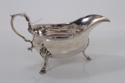 Lot 3 - George V silver sauce boat of helmet form with gadrooned border raised on three hoof feet, (London 1917), maker Pairpoint Bros, 16.6cm long, (6.8oz)