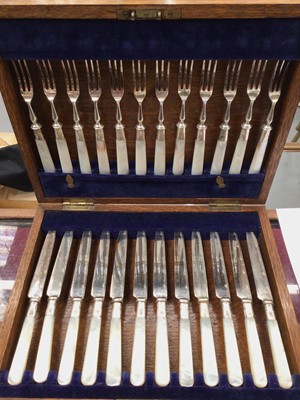 Lot 901 - 1920s set of twelve silver plated dessert knives and forks with mother of pearl handles and silver mounts, in fitted case