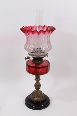 Lot 793 - Late Victorian oil lamp with cranberry tinted and etched glass shade with cranberry cut glass reservoir on brass and black ceramic base