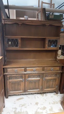 Lot 1142 - Old Charm carved oak two height dresser with open shelves and two small leaded glazed doors above, three drawers and three linenfold panelled doors below, 136cm wide, 43cm deep, 175cm high