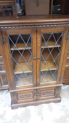 Lot 1143 - Old Charm oak bookcase with adjustable shelves enclosed by two leaded glazed doors with two carved panelled doors below, 80cm wide, 28cm deep, 127cm high