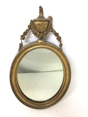 Lot 1417 - Regency gilt oval wall mirror with urn cresting