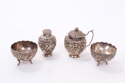 Lot 434 - Japanese silver four piece cruet set comprising mustard pot, pepperette and pair of salt cellars, with floral decoration in relief, marked to base