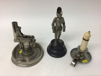 Lot 2447 - Three novelty lighters, including a candle, a gun and a knight in armour