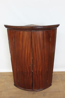 Lot 1338 - George III mahogany bow fronted, double door corner cupboard