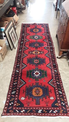 Lot 1346 - Large Eastern runner with seven central medallions on red and blue ground