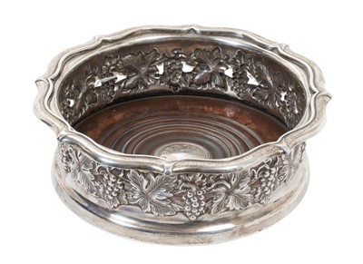 Lot 363 - William IV silver wine coaster of circular form, with pierced and embossed border depicting fruiting vines, turned wood base and inset silver disc (London 1833) Maker Kitchen, Walker & Kerr, 15.5cm...