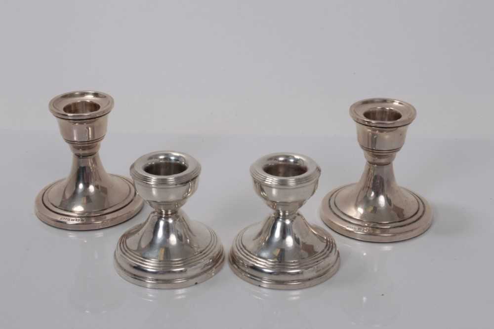 Lot 147 - Two pairs of Elizabeth II dwarf silver candlesticks (Birmingham 1958 / 1967), 7 and 5.5cm in height (4)