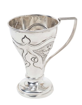 Lot 410 - Edwardian silver christening mug of tapered form with embossed Art Nouveau style floral decoration, panel with engraved inscription, reeded handle and raised on domed circualar foot (Chester 1905)...