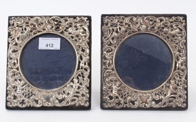 Lot 412 - Pair of Edwardian photograph frames of square form, with applied silver relief panels with scroll and cherub decoration, (London 1903), maker William Comys, 16.5 x 16.5cm (2)