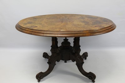 Lot 1435 - Victorian figured burr walnut veneered and marquetry inlaid oval table with tilt top on carved walnut pedestal base with four scroll legs