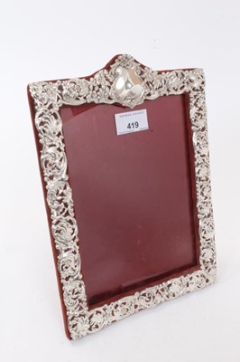 Lot 419 - Late Victorian silver mounted photograph frame of rectangular form with relief floral, foliate and scroll decoration (Birmingham 1899), maker Henry Manton, 28 x 20.5cm overall.