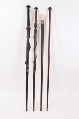 Lot 1017 - Edwardian walking stick with amethyst glass knop, ivory handled cane and two African hardwood canes with African head and snake decoration (4)