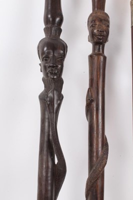 Lot 1017 - Edwardian walking stick with amethyst glass knop, ivory handled cane and two African hardwood canes with African head and snake decoration (4)