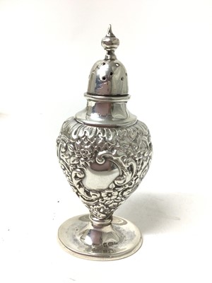 Lot 237 - Sterling silver caster, relief-decorated in the rococo style, together with a plated egg cruet and a plated sugar cattle and scoop