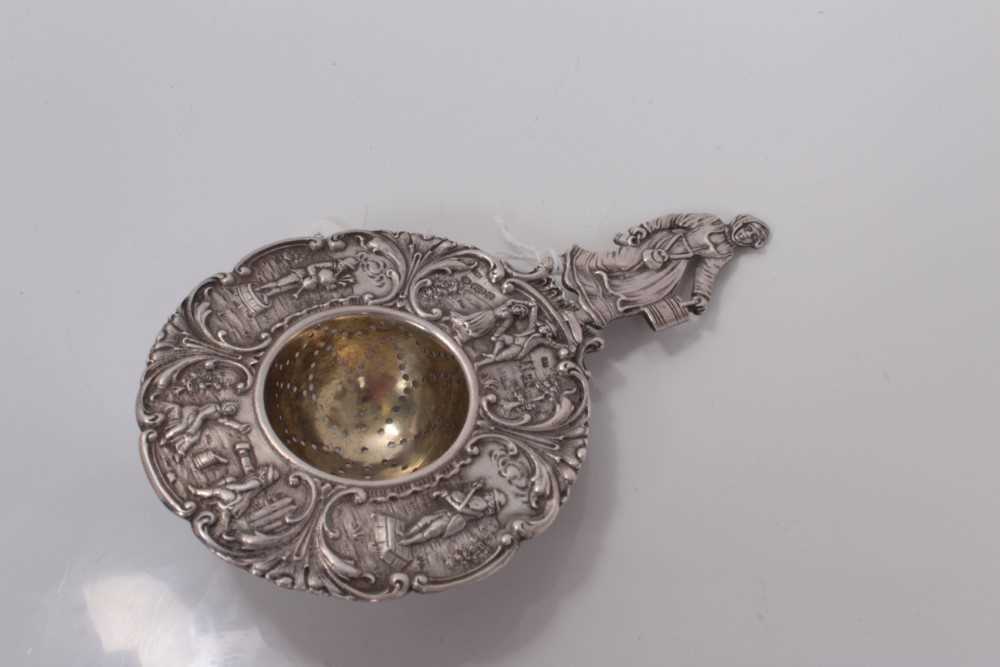 Lot 39 - Early 20th century Dutch silver tea strainer with figural decoration, stamped 830 and with import marks for Chester 1904, 15.5cm in length.