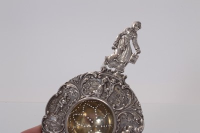 Lot 39 - Early 20th century Dutch silver tea strainer with figural decoration, stamped 830 and with import marks for Chester 1904, 15.5cm in length.