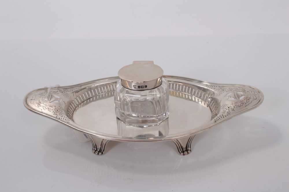 Lot 63 - Edwardian silver inkstand with pierced and engraved decoration and central cut glass inkwell with silver mount, (Sheffield 1908), maker Hawksworth, Eyre & Co Ltd, stand 22cm in length, 4ozs of weig...