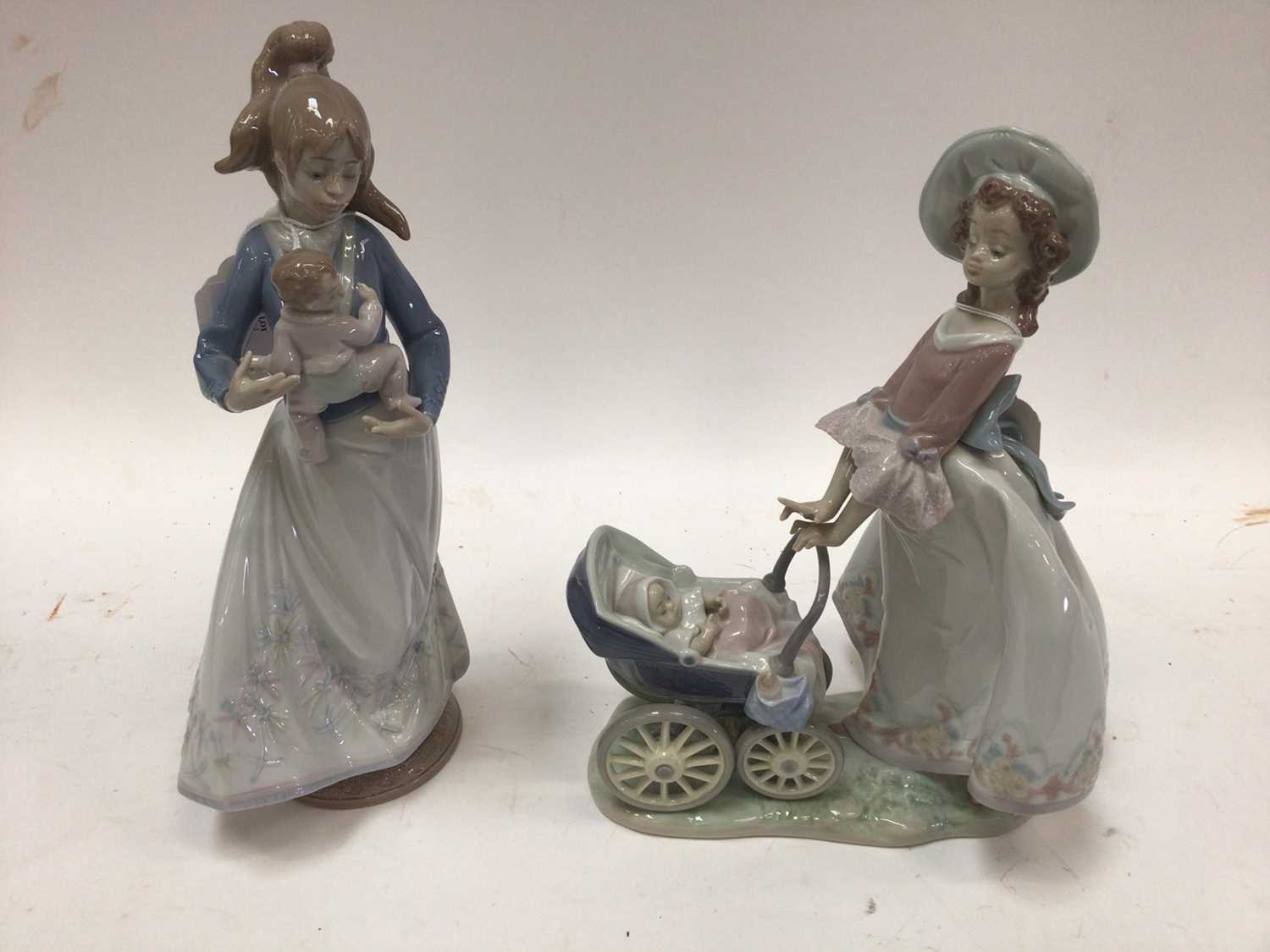 Lot 1061 - Two Lladro porcelain figures - Lady holding baby and Lady with pushchair and baby