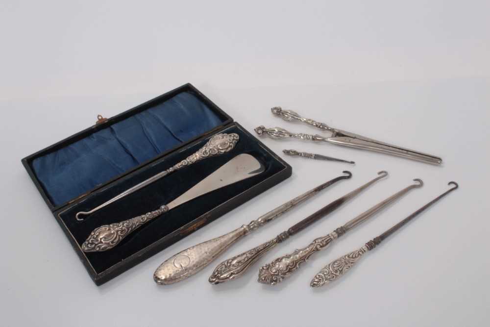 Lot 146 - Group of six silver handled button hooks, including one in a fitted case with a shoe horn and a pair of silver handled glove stretchers, (various dates and makers), (8)