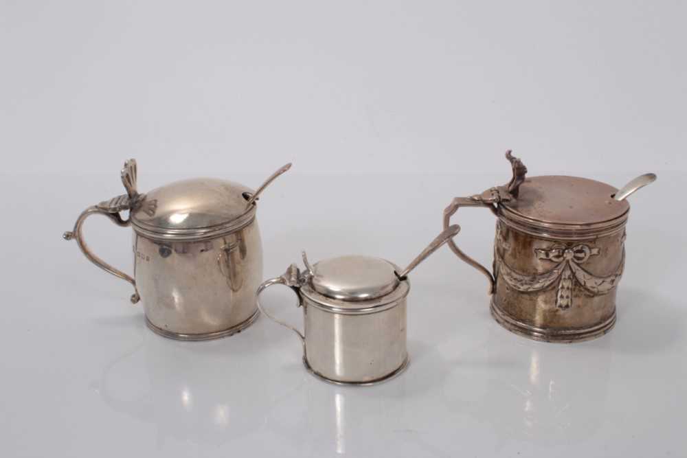 Lot 169 - Victorian silver mustard pot with embossed ribbon and swag decoration, (London 1888), together with two other silver mustard pots and three associated silver spoons (various dates and makers) all a...