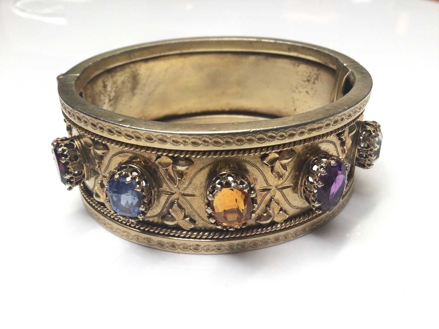 Lot 11 - Antique silver gilt cuff bangle set with five various coloured gem stones and applied leaf decoration
