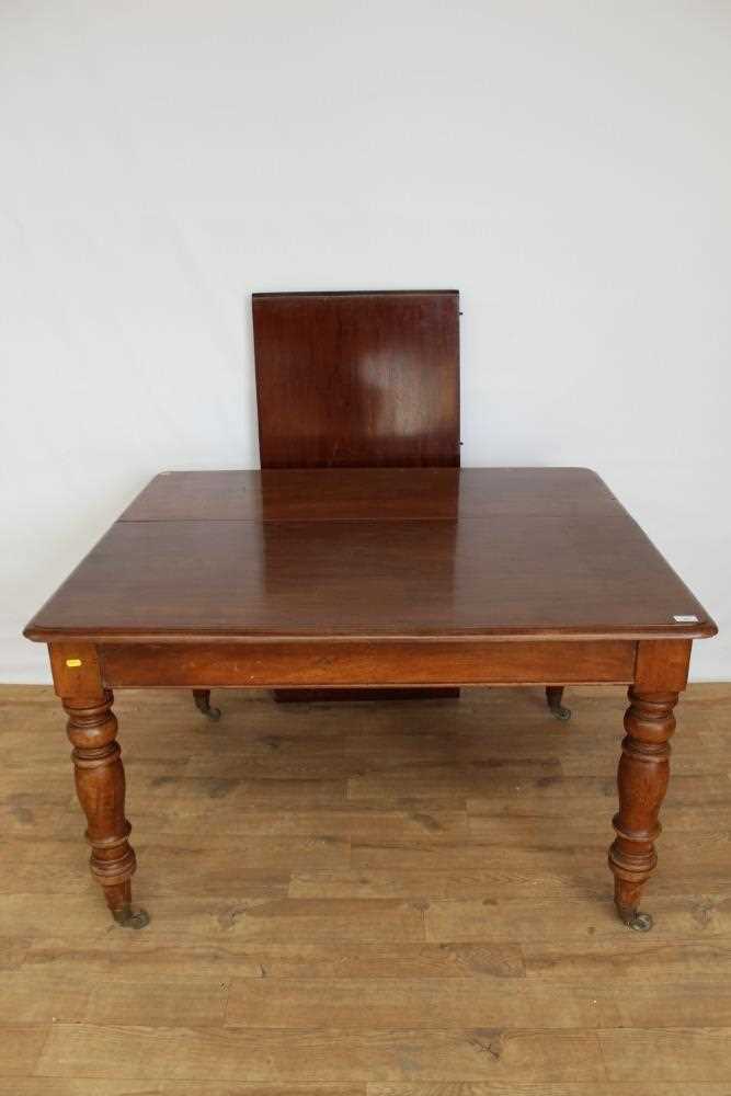 Lot 52 - Victorian mahogany extending dining table with one extra leaf on turned legs and brass capped castors, opening to 157cm x 119cm