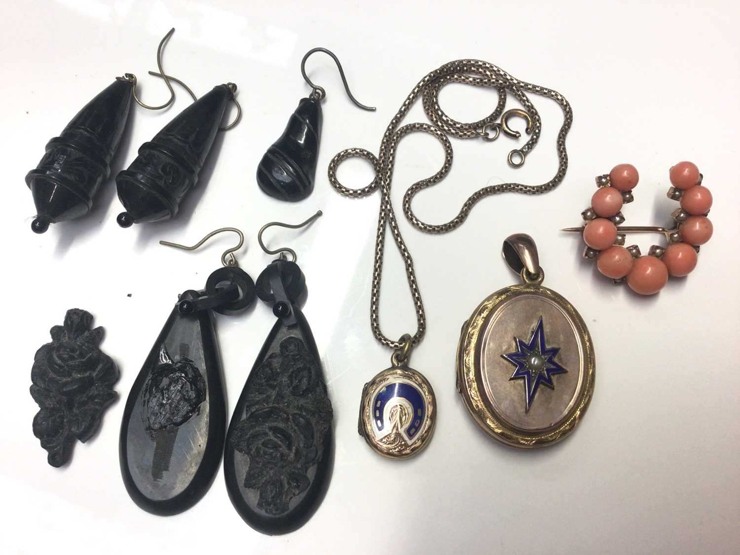 Lot 23 - Victorian coral and seed pearl horseshoe shaped brooch, two antique mourning lockets with enamel decoration and a small selection of jet earrings