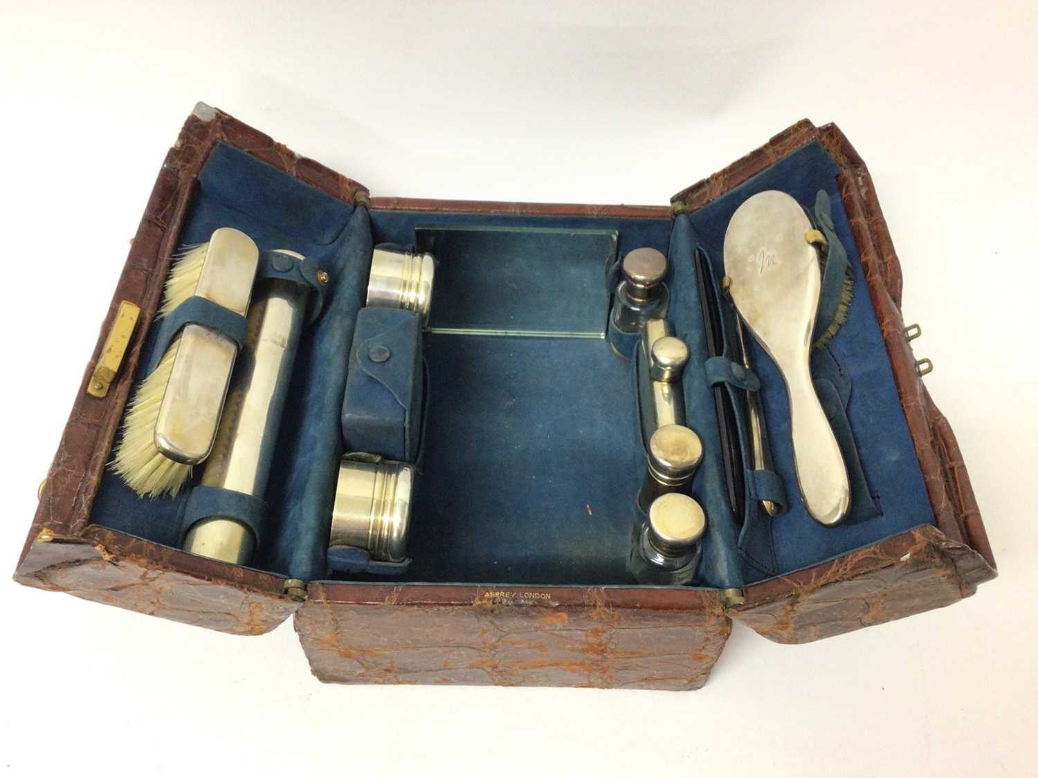 Lot 80 - Asprey crocodile leather vanity case containing Asprey silver mounted dressing table items