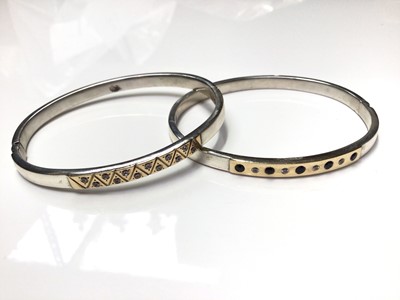 Lot 74 - Two white metal bangles, both with yellow metal panels set with synthetic stones