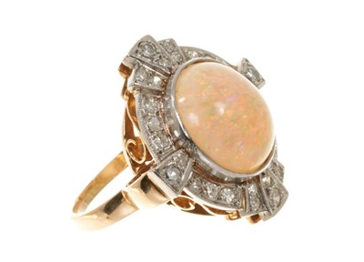 Lot 513 - Art Deco style opal and diamond cluster ring with an oval cabochon opal surrounded by a border of diamonds in platinum millegrain setting with pierced gold gallery on gold shank.
