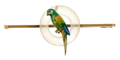 Lot 516 - Art Deco crystal and gold and enamel brooch with polychrome enamelled gold parrot perched in a frosted crystal/glass ring, mounted on a gold bar brooch fitting.