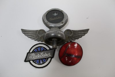 Lot 2016 - Studebaker bonnet mascot / radiator cap, together with a Studebaker enamel badge and cloth badge (3)