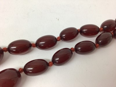 Lot 106 - Simulated cherry amber necklace with graduating polished oval beads, 77cm long