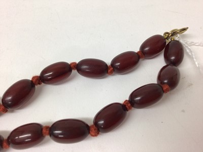 Lot 106 - Simulated cherry amber necklace with graduating polished oval beads, 77cm long