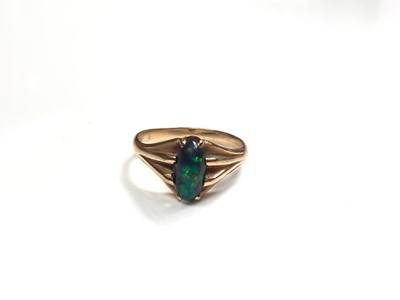 Lot 141 - Black opal ring in claw setting with reeded shoulders on yellow metal shank