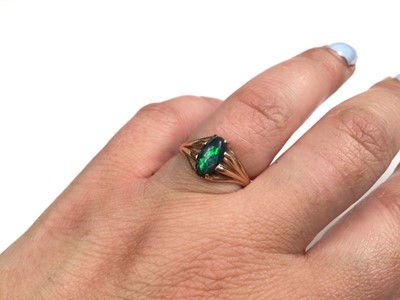 Lot 141 - Black opal ring in claw setting with reeded shoulders on yellow metal shank