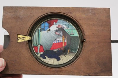 Lot 1824 - Two Victorian coloured animated winding Magic Lantern slides, man in bed with mouse and man with ship's wheel.