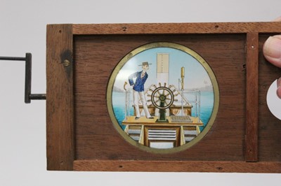 Lot 1824 - Two Victorian coloured animated winding Magic Lantern slides, man in bed with mouse and man with ship's wheel.