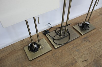 Lot 177 - Trio of contemporary brushed brass finished lamps comprising standard lamp and pair of table lamps, with rectangular shades
