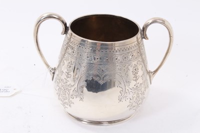 Lot 368 - Victorian silver three piece teaset comprising teapot of tapered cylindrical form with overall engraved foliate and scroll decoration and handle with ivory insulators.