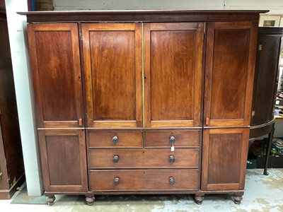 Lot 1327 - 19th century mahogany compactum wardrobe with central chest of four drawers, 
press above, flanked by hanging spaces on turned feet.