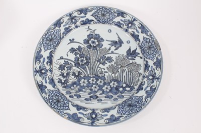 Lot 13 - A blue and white Dutch delftware dish, circa 1700, painted in the Oriental style with birds amongst flowers, with a foliate-patterned border, GK mark to base for Gerrit Kam, 34cm diameter