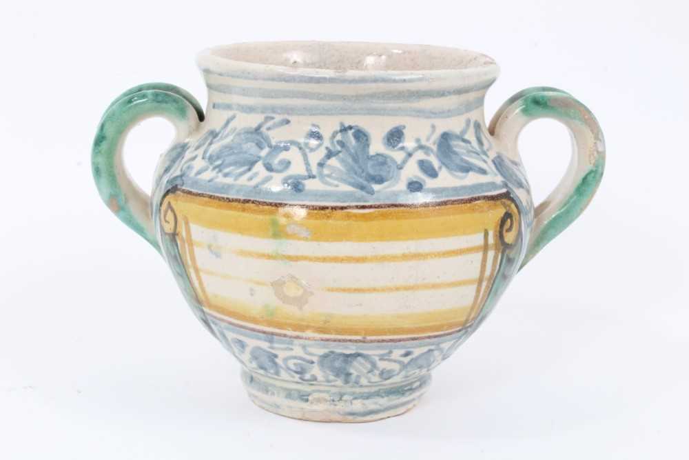 Lot 27 - An unusual Italian maiolica twin-handled pot, with blank scrollwork cartouche, probably an apothecary jar, 11cm high