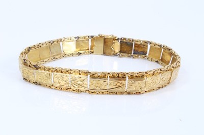 Lot 559 - Yellow metal panel bracelet with engraved scroll decoration