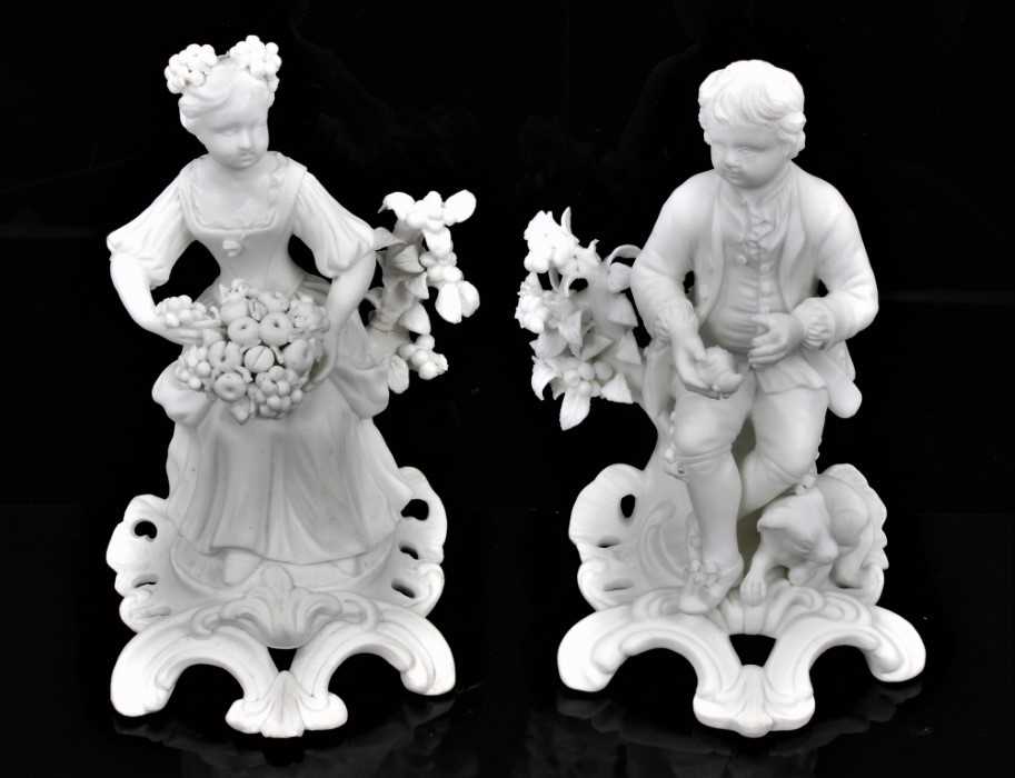 Lot 50 - A pair of Derby bisque figures of a boy and a girl, late 18th/early 19th century, shown seated on scrolled rococo bases, the girl holding a basket of fruit, the boy holding a game bird and with a h...