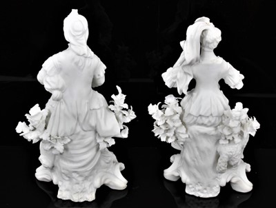 Lot 53 - A pair of Derby bisque figures of a shepherd and shepherdess, shown seated on scrolled rococo bases, the shepherd playing bagpipes and with a hound by his side, the shepherdess playing the lute wit...