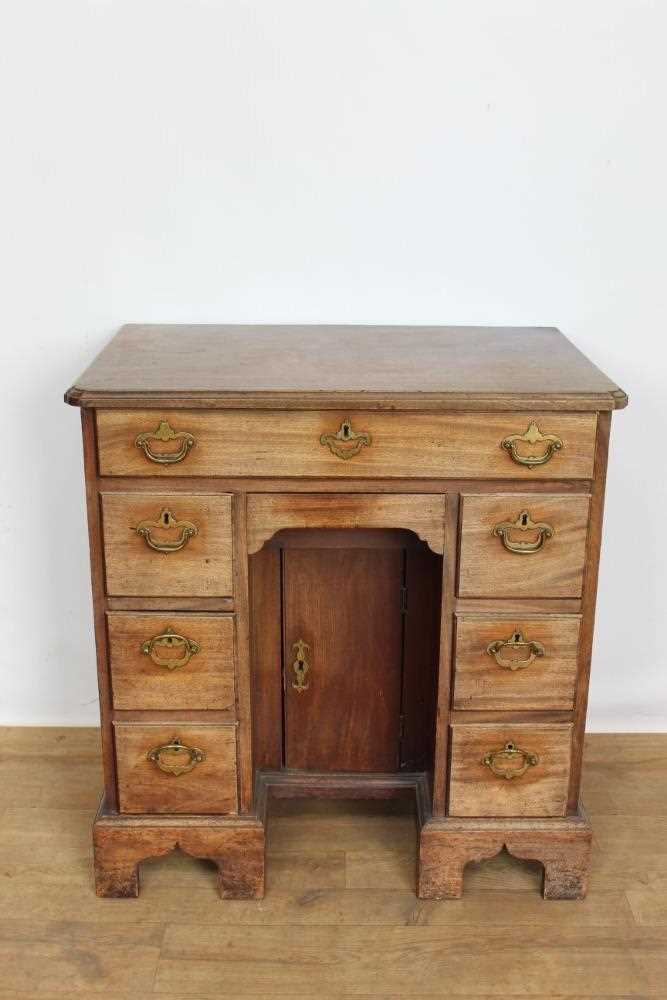 Lot 1269 - George II mahogany kneehole dressing table, the top with re-entrant angles and seven drawers and flush concealed apron drawer about the cupboard kneehole, 76cm x 50cm x 80cm