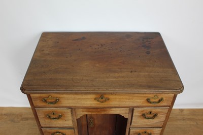 Lot 1269 - George II mahogany kneehole dressing table, the top with re-entrant angles and seven drawers and flush concealed apron drawer about the cupboard kneehole, 76cm x 50cm x 80cm